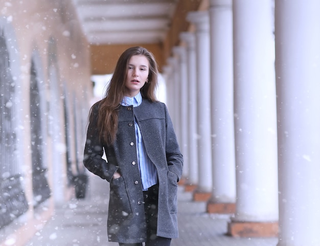 Młoda dziewczyna na zewnątrz w zimie. Model dziewczyna pozuje na zewnątrz w zimowy dzień. Świąteczny weekend na ulicy spaceru dziewczyna.