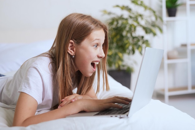 Młoda dziewczyna pracuje w domu na laptopie, szkolenie online