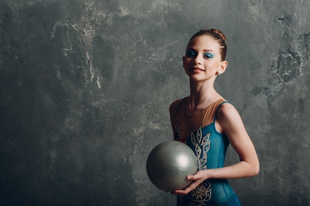 Młoda dziewczyna profesjonalna gimnastyczka kobieta portret gimnastyka artystyczna z piłką w studio