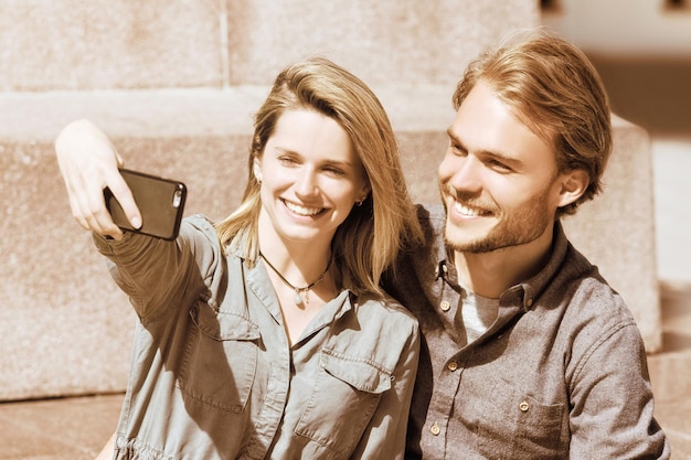 Młoda dziewczyna robi selfie ze swoim chłopakiem jako koncepcja przyjaźni i wspólnoty