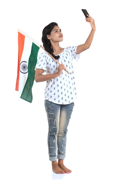 Młoda Dziewczyna świętuje Dzień Niepodległości Indii Lub Dzień Republiki Indii Za Pomocą Telefonu Komórkowego Z Flagą Indii Lub Trójkolorowym Na Białym Tle