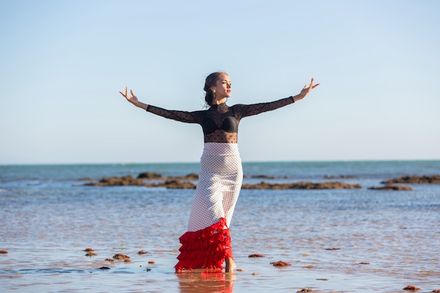 Młoda Dziewczyna Tańczy Flamenco Na Aguan Na Plaży W Typowym Stroju Andaluzyjskim