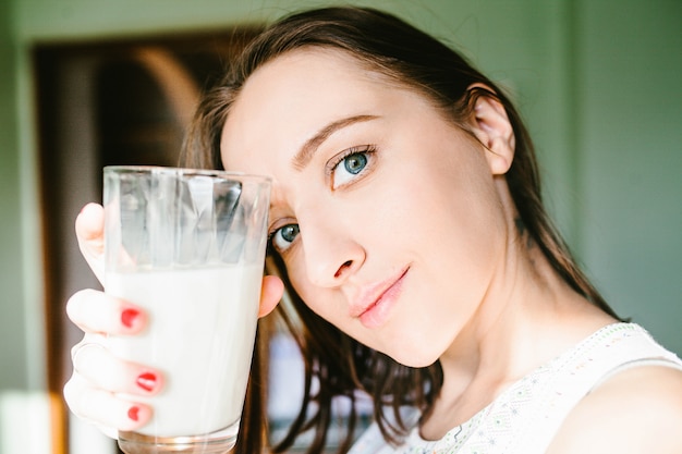 Zdjęcie młoda dziewczyna trzyma szklankę mleka