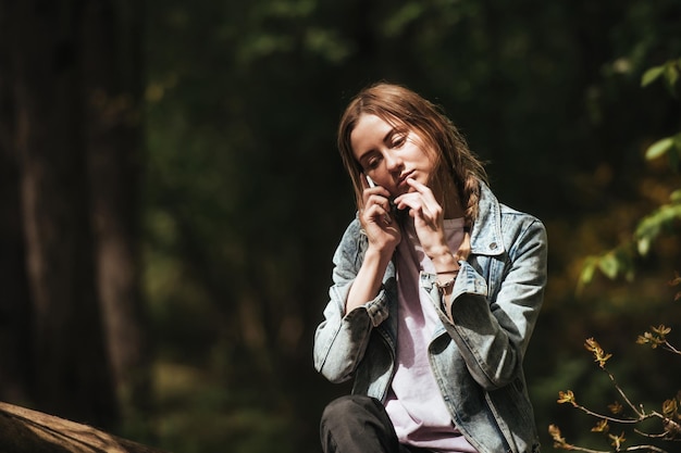 młoda dziewczyna turysta w zielonym lesie rozmawia przez telefon