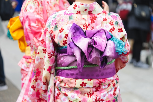 Młoda dziewczyna ubrana w japońskie kimono stojące przed świątynią Sensoji w Tokio,