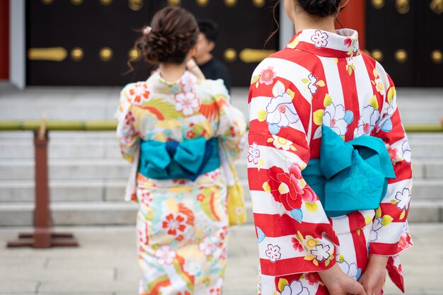 Młoda dziewczyna ubrana w japońskie kimono stojące przed świątynią Sensoji w Tokio,