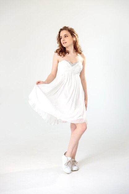 Zdjęcie młoda dziewczyna w białej sukni na białym tle