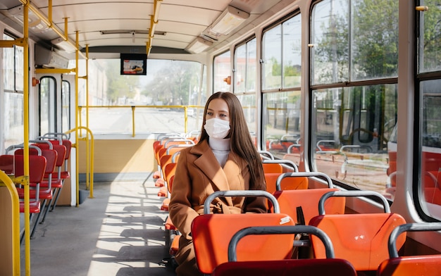 Młoda dziewczyna w masce podczas pandemii korzysta wyłącznie z transportu publicznego. Ochrona i zapobieganie covid 19.