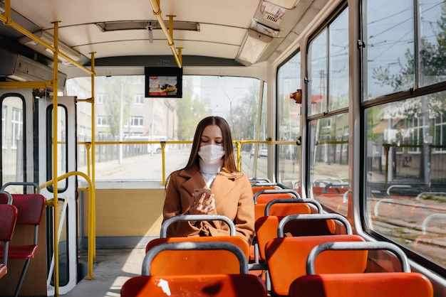 Młoda dziewczyna w masce podczas pandemii korzysta wyłącznie z transportu publicznego. Ochrona i zapobieganie covid-19.