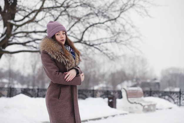 Młoda dziewczyna w parku zimowym na spacerze Święta Bożego Narodzenia w zimowym lesie Dziewczyna cieszy się zimą w parku