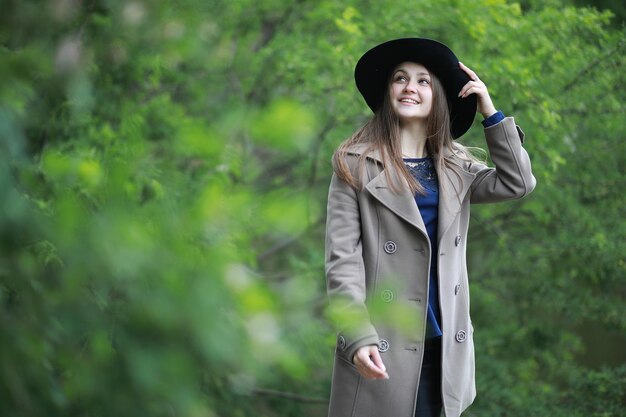 Młoda dziewczyna w płaszczu w wiosennym parku w deszczuxA