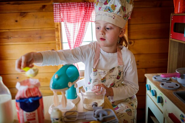 Zdjęcie młoda dziewczyna w wendy house udaje, że gotuje w kuchni