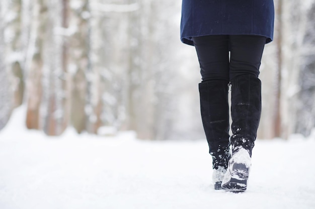 Młoda dziewczyna w winter park na spacerze. Święta Bożego Narodzenia w zimowym lesie. Dziewczyna cieszy się zimą w parku.