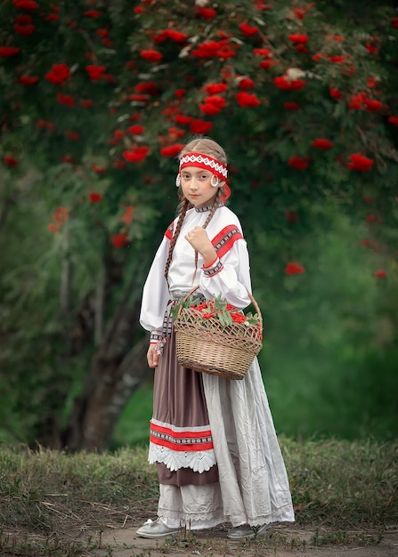 Zdjęcie młoda dziewczyna z koszem pełnym jarzębiny w dłoniach