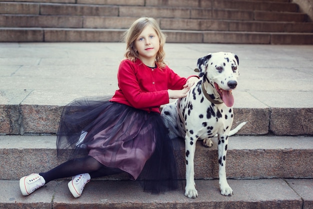 Młoda dziewczyna z psami Dalmacji w wiosennym parku.