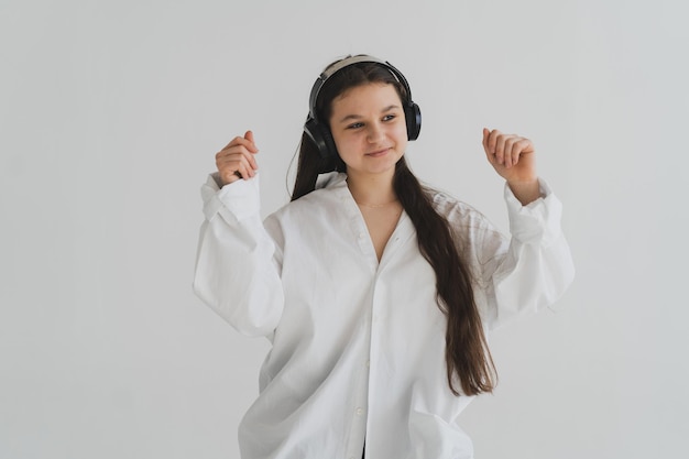 Młoda dziewczyna ze słuchawkami słucha muzyki i tańca