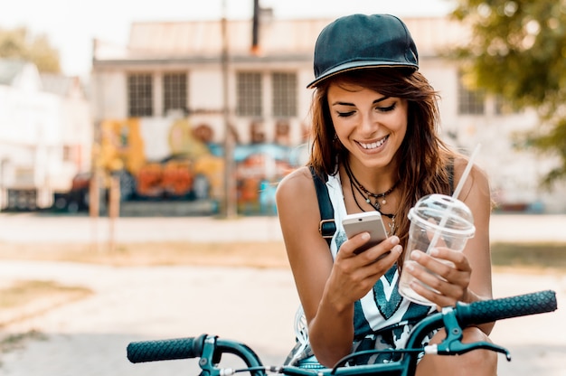 Młoda Elegancka Kobieta Z Bicyklem Używać Telefon Komórkowego.