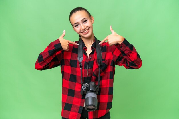Młoda fotografka Arabka na odosobnionym tle dumna i zadowolona z siebie
