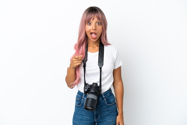 Młoda Fotografka Mieszanej Rasy Kobieta Z Różowymi Włosami Na Białym Tle Zaskoczona I Wskazująca Przód