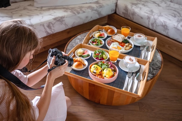 Młoda fotografka robi sesję zdjęciową świeżego śniadania w hotelu?