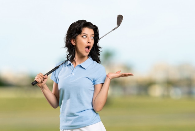 Młoda golfista kobieta z niespodzianka wyrazem twarzy przy outdoors