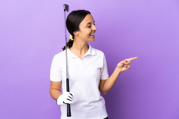 Młoda golfistka nad odosobnioną kolorową ścianą zamierza realizować rozwiązanie, podnosząc palec w górę