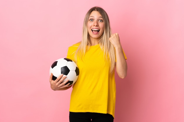 Młoda gracz futbolu kobieta odizolowywająca na menchii ścianie świętuje zwycięstwo