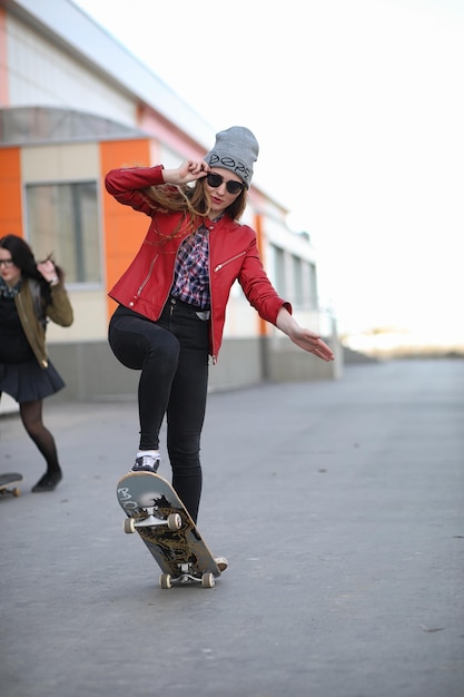 Młoda hipsterka jedzie na deskorolce Dziewczyny na spacer po mieście z deskorolką Wiosenne sporty na ulicy z deskorolkąxA