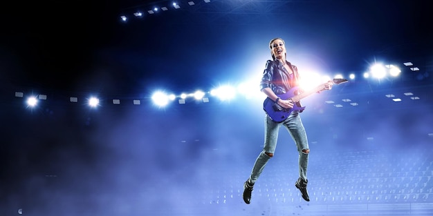 Młoda i piękna rockowa dziewczyna gra na gitarze elektrycznej. Różne środki przekazu