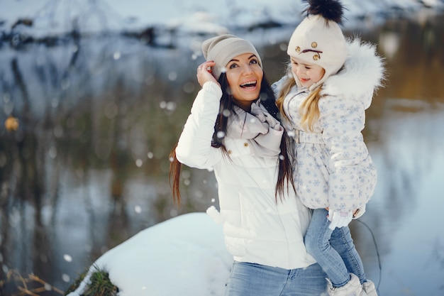 Młoda I Stylowa Mama Gra Z Jej Małą Córeczkę W Parku śniegu Zimą