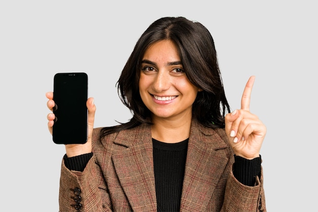 Młoda indyjska biznesowa kobieta pokazuje jej telefon komórkowy odizolowywającego wycinającego