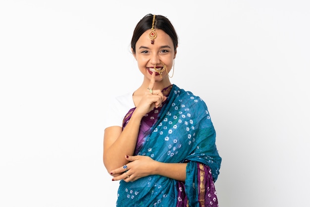 Młoda indyjska kobieta na biel ścianie pokazuje znak cisza gesta kładzenia palec w usta