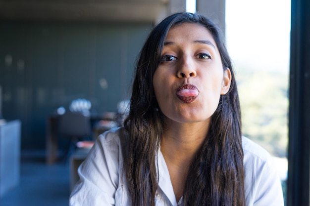 Zdjęcie młoda indyjska kobieta pokazująca język