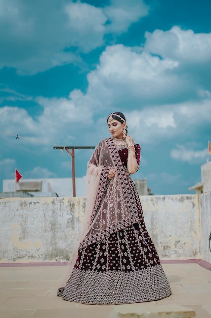 Młoda indyjska panna młoda w luksusowym kostiumie ślubnym z makijażem i ciężką biżuterią