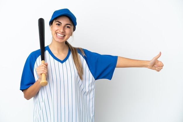 Młoda kaukaska kobieta gra w baseball na białym tle, dając gest kciuka w górę