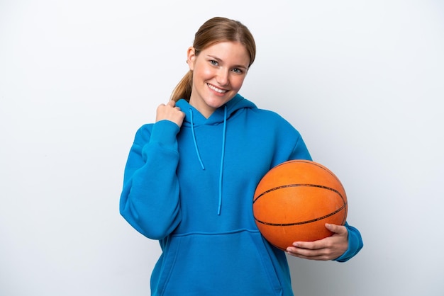 Młoda kaukaska kobieta gra w koszykówkę na białym tle śmiejąc się