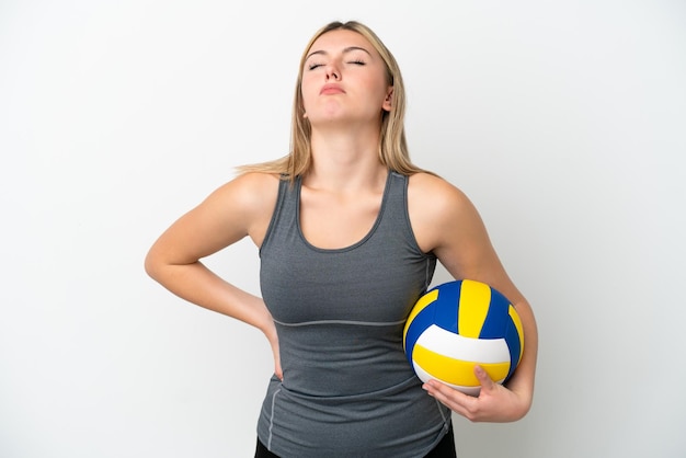 Młoda kaukaska kobieta grająca w siatkówkę na białym tle cierpiąca na ból pleców za wysiłek