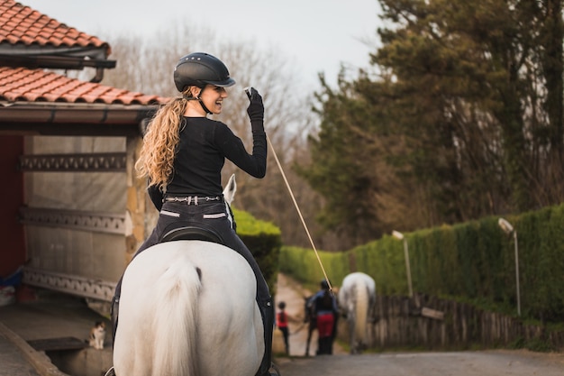 Zdjęcie młoda kaukaska kobieta na koniu w ośrodku dla koni horse