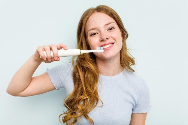 Młoda Kaukaska Kobieta Trzyma Elektryczną Szczoteczkę Do Zębów Na Białym Tle Na Niebieskim Tle