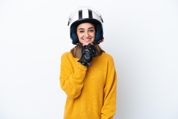 Młoda kaukaska kobieta z kaskiem motocyklowym na białym tle szczęśliwa i uśmiechnięta