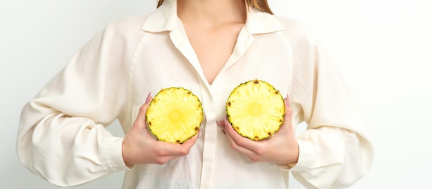 Młoda kaukaska uśmiechnięta kobieta trzyma plasterki ananasa na białym tle koncepcja zdrowia piersi