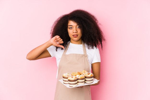 Młoda kobieta afro cukiernik trzyma cupcake