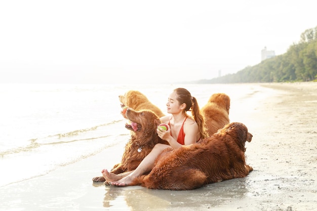 Młoda kobieta bawi się ze swoimi psami na plaży Koncepcja zdrowego, aktywnego stylu życia Relaks ze zwierzakiem