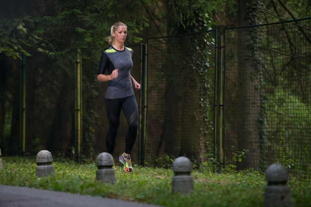 Młoda kobieta bieganie w zalesionym terenie leśnym - trening i ćwiczenia na wytrzymałość Trail Run Marathon - koncepcja zdrowego stylu życia Fitness