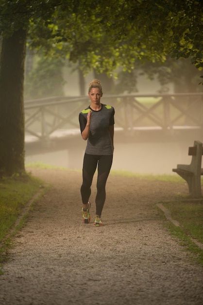 Młoda kobieta bieganie w zalesionym terenie leśnym - trening i ćwiczenia na wytrzymałość Trail Run Marathon - koncepcja zdrowego stylu życia Fitness