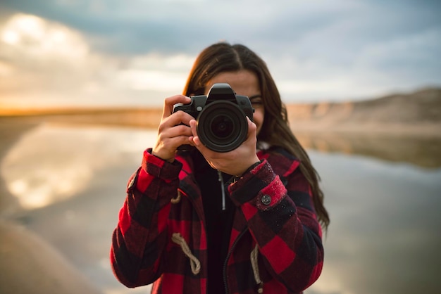 Młoda kobieta bierze obrazek z kamerą na plaży