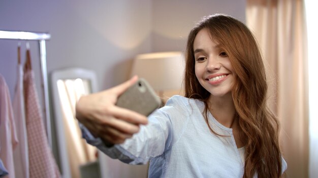 Zdjęcie młoda kobieta bierze selfie na telefonie komórkowym w domu szczęśliwa kobieta robi selfie
