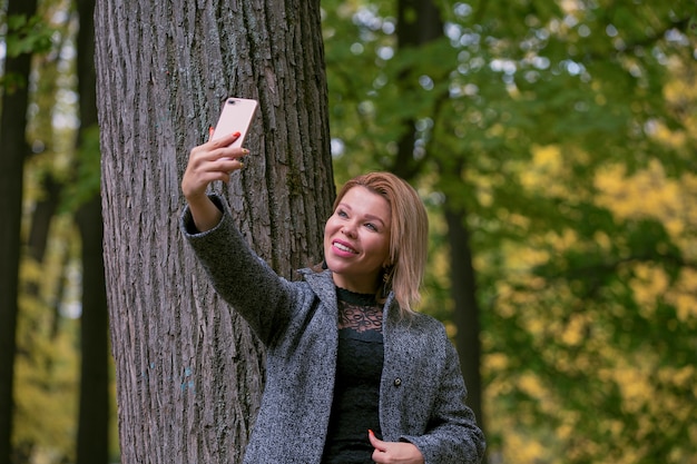 Młoda kobieta bierze selfie przy parkiem