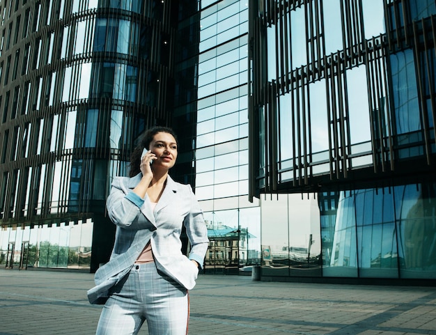 Młoda Kobieta Biznesu Korzysta Z Telefonu Komórkowego Przed Nowoczesnym Centrum Biznesowym