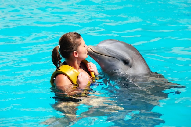 Młoda Kobieta Całująca Delfina W Turkusowej Wodzie
